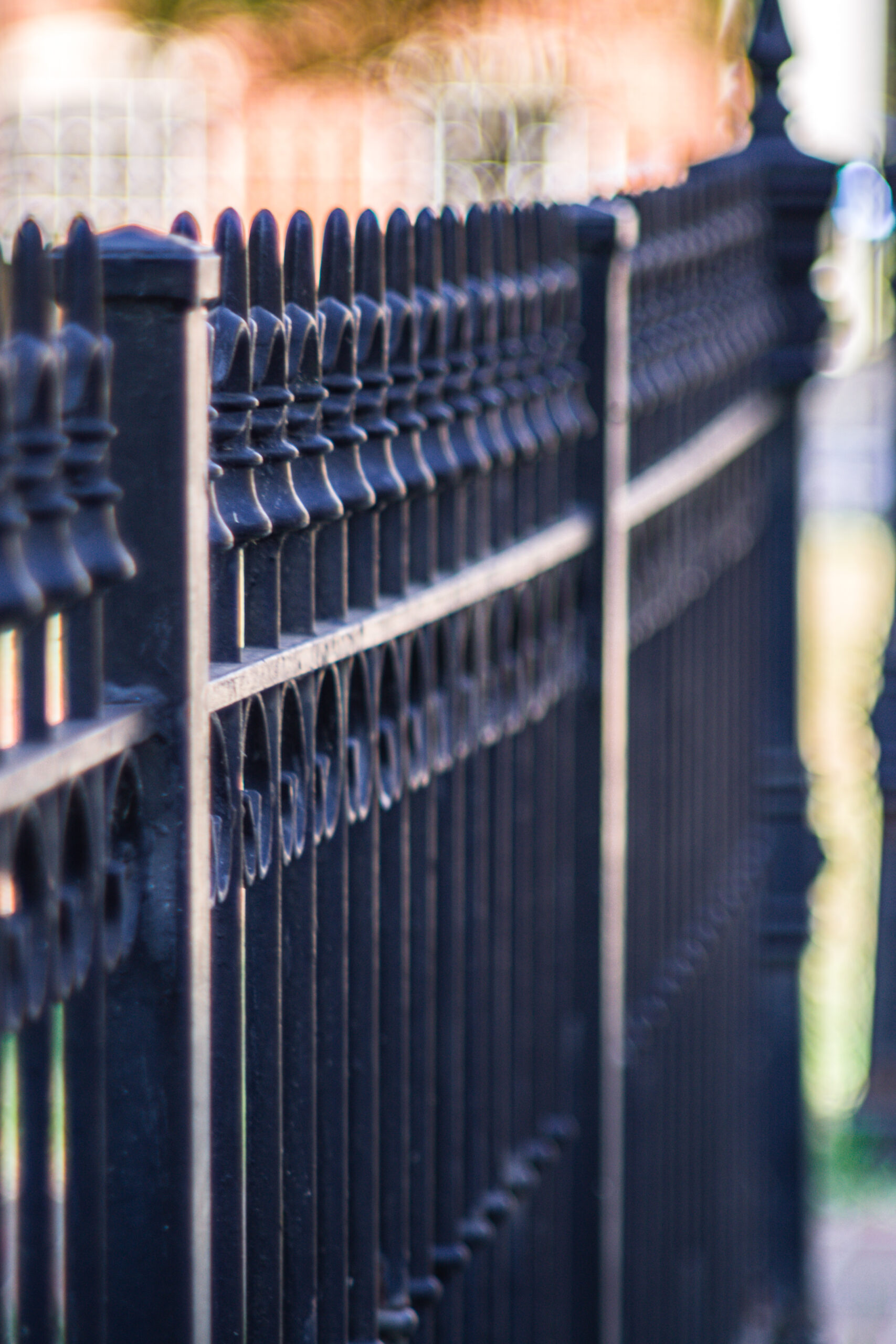 A vertical closeup shot of a metal fence on a sidewalk
